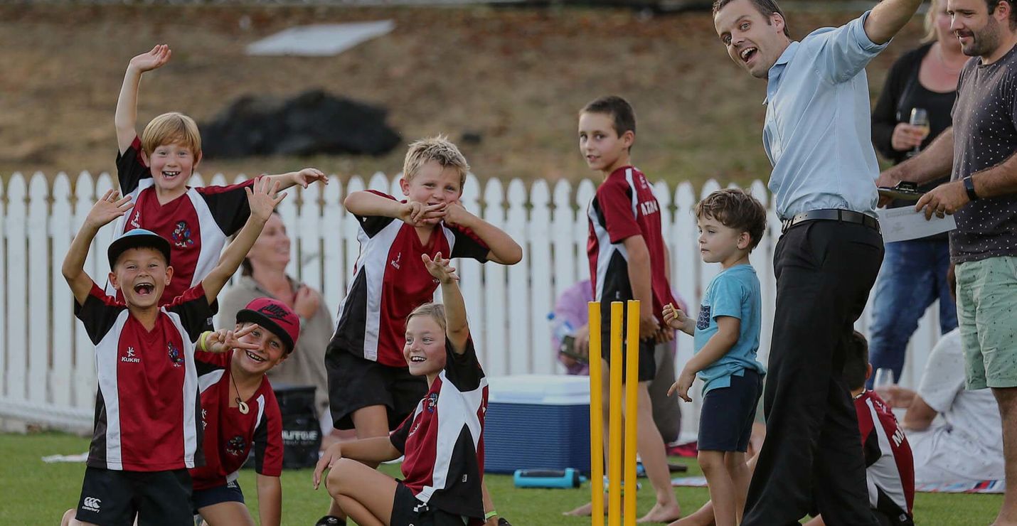Kids posing on a cricket pitch